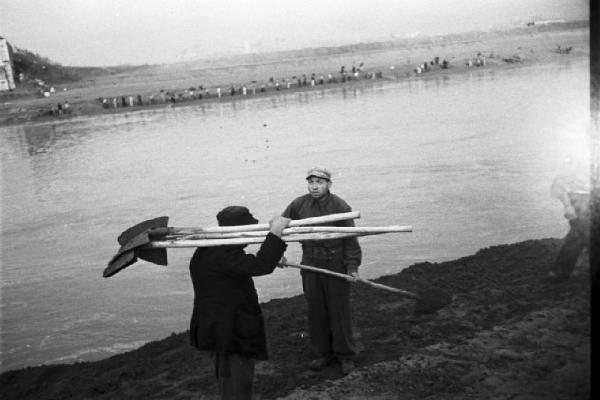 Italia Dopoguerra. Roma. Ponte sul Tevere in costruzione. Opere di sbancamento lungo la sponda del fiume. Operai muniti di vanghe