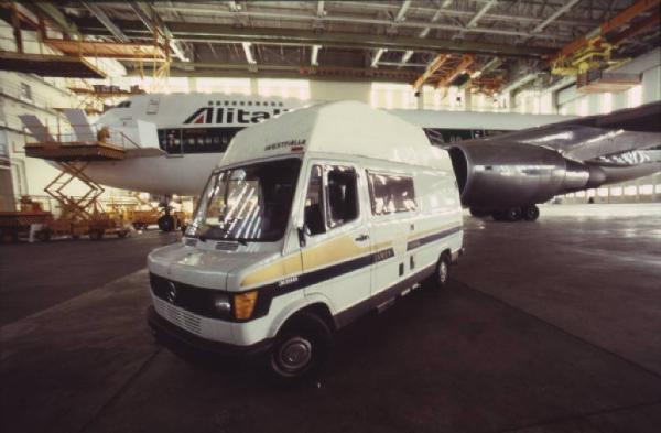 Alitalia. Interno di un hangar - aeroplano della compagnia di bandiera e furgone di servizio