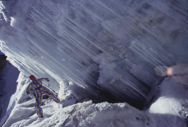 Campagna pubblicitaria Ellesse. Fotomodella indossa tuta da sci arlecchino - neve - cascata ghiacciata