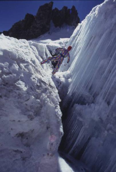 Campagna pubblicitaria Ellesse. Fotomodella indossa tuta da sci arlecchino - neve - cascata ghiacciata