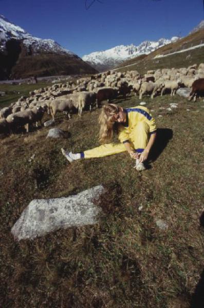 Campagna pubblicitaria Ellesse. Fotomodella indossa tuta da ginnastica gialla - prati di un alpeggio - gregge di pecore