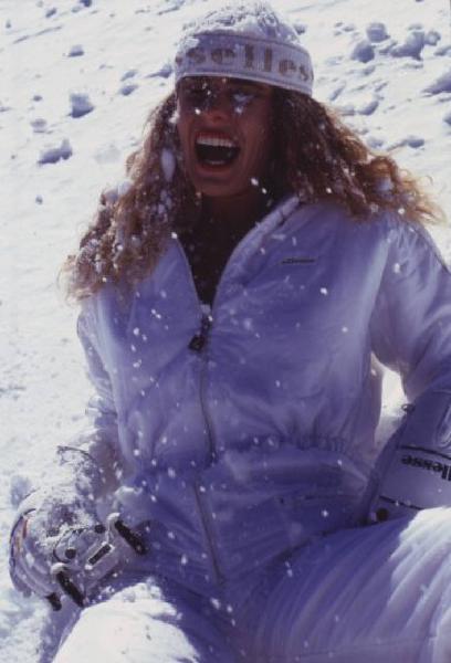 Campagna pubblicitaria Ellesse. Fotomodella indossa tuta da sci bianca - cappello - neve