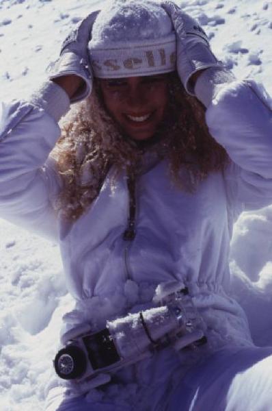 Campagna pubblicitaria Ellesse. Fotomodella indossa tuta da sci bianca - cappello - neve