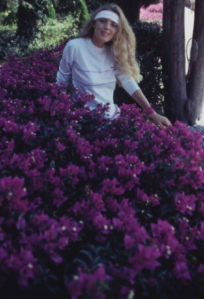 Campagna pubblicitaria Ellesse. Fotomodella indossa un completo da tennis - fiori di bouganville