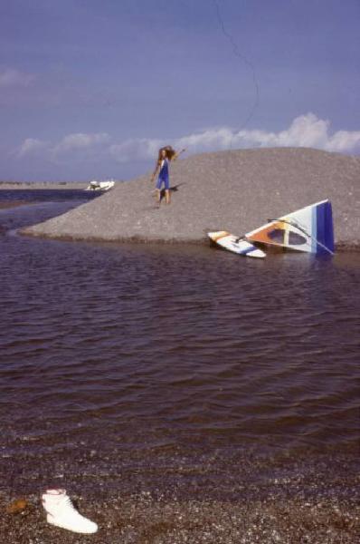 Campagna pubblicitaria Ellesse. Fotomodella indossa una muta - torrente - scarpa da ginnastica - windsurf