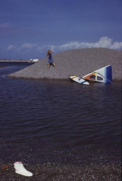 Campagna pubblicitaria Ellesse. Fotomodella indossa una muta - torrente - scarpa da ginnastica - windsurf