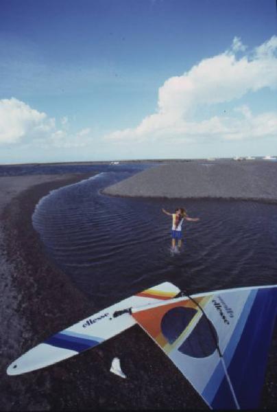 Campagna pubblicitaria Ellesse. Fotomodella indossa una muta - torrente - scarpa da ginnastica - windsurf