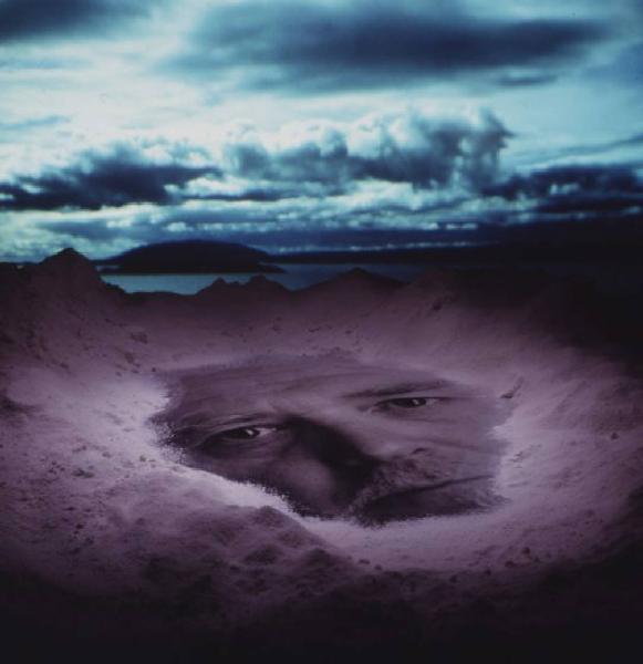 Klaustrofobia. Ritratto maschile - autoritratto dell'artista proiettato su una spiaggia. Luce del mattino