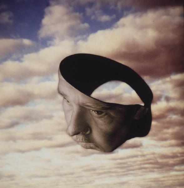 Klaustrofobia. Ritratto maschile - autoritratto dell'artista "Maschera" su fondale "Cielo". Luce giallastra