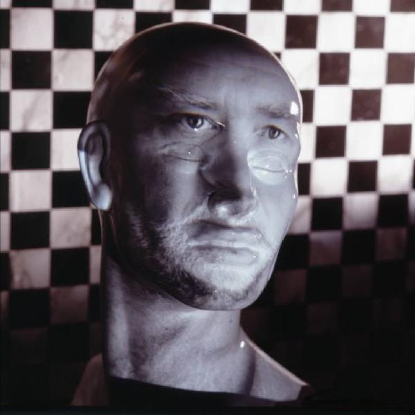 Klaustrofobia. Ritratto maschile - autoritratto dell'artista "Maschera Pelata" proiettato su fondale a scacchiera
