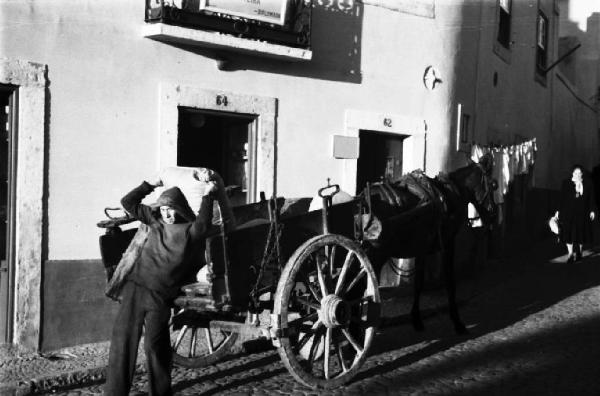 Lisbona. Quartiere arabo - carro trainato da un cavallo. Operaio scarica un sacco