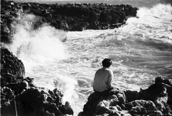 Cascais. Ragazzino osserva le onde che frangono sulla scogliera