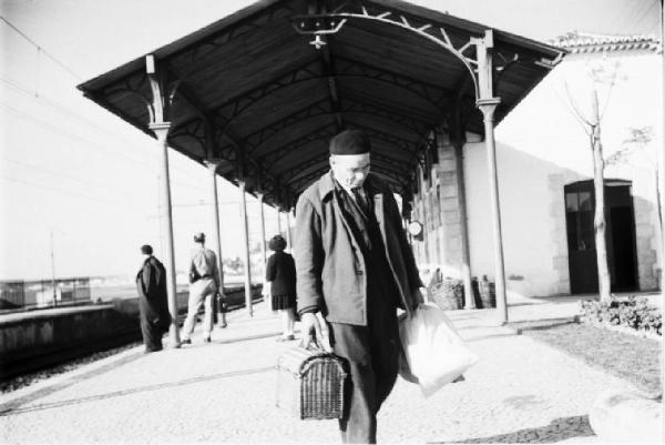 Cascais. Stazione ferroviaria - passeggero con cesta e sacchetti