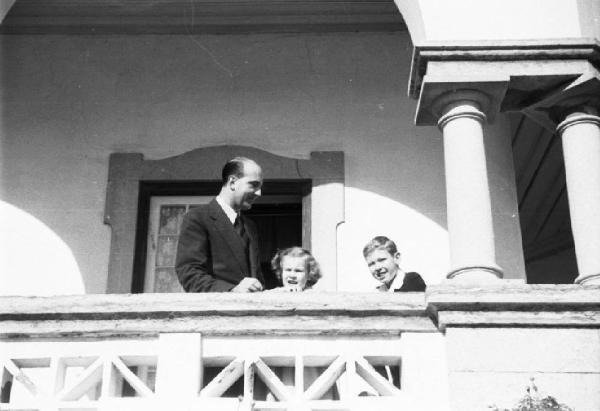 Estoril. Famiglia Savoia in esilio. Umberto II, Maria Gabriella e Vittorio Emanuele IV affacciati alla loggia della villa
