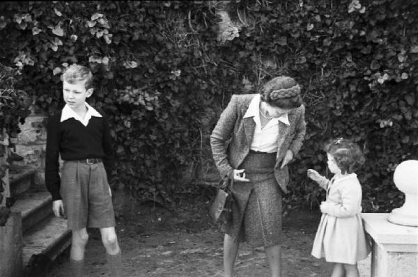 Estoril. Famiglia Savoia in esilio. Vittorio Emanuele IV, l'istitutrice e Maria Beatrice in giardino