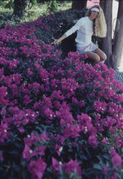 Campagna pubblicitaria Ellesse. Fotomodella indossa un completo da tennis - fiori di bouganville