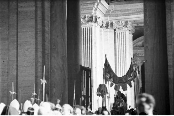 Città del Vaticano. Basilica di San Pietro. Il baldacchino con Papa Pio XII attraversa la folla dei fedeli - in primo piano gli elmi e le lance delle Guardie Svizzere