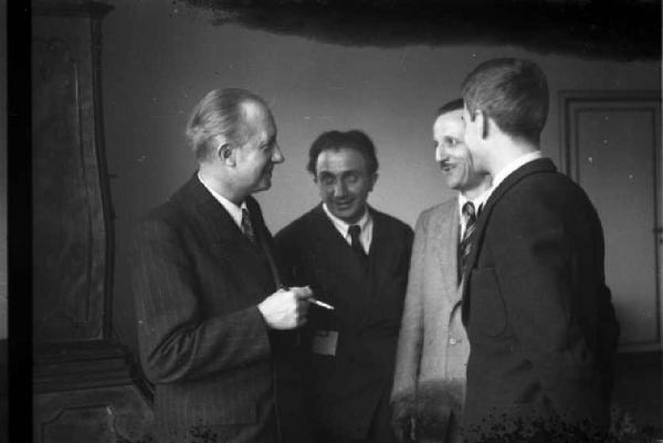 Quattro uomini politici discutono in una stanza