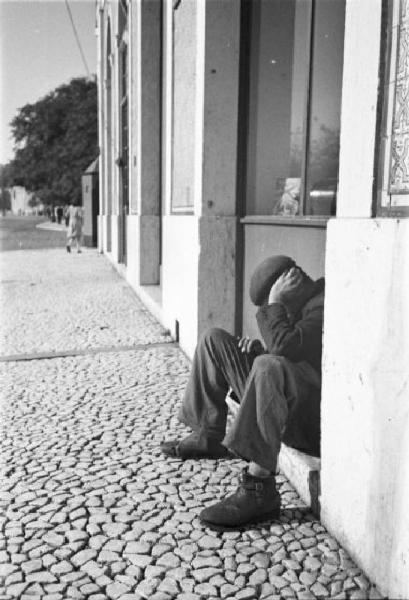 Lisbona. Uomo seduto per strada