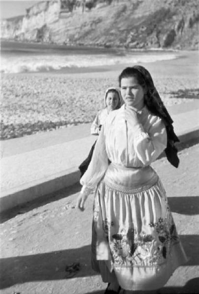 Nazaré - lungomare. Giovane donna in abiti tradizionali