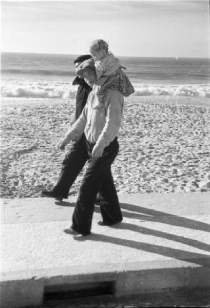 Nazaré - lungomare. Uomo con bambino in spalla