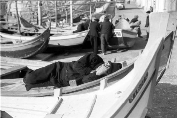 Nazaré - uomo dorme su una barca da pesca