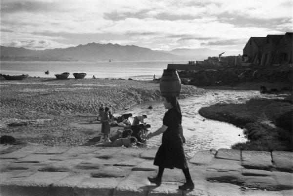 Cangas - la spiaggia con la bassa marea. Donna cammina sul lungomare