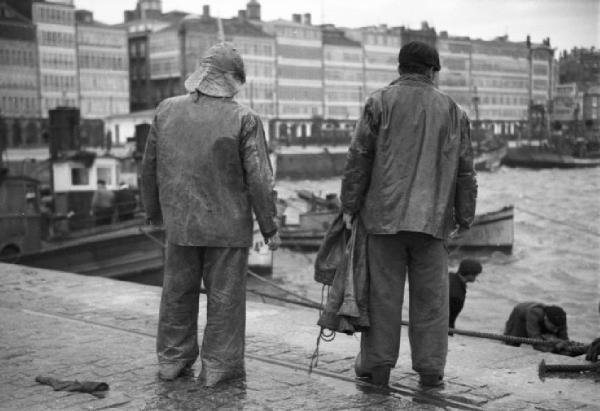 La Coruna - due pescatori osservano le acque del porto agitate da una tempesta