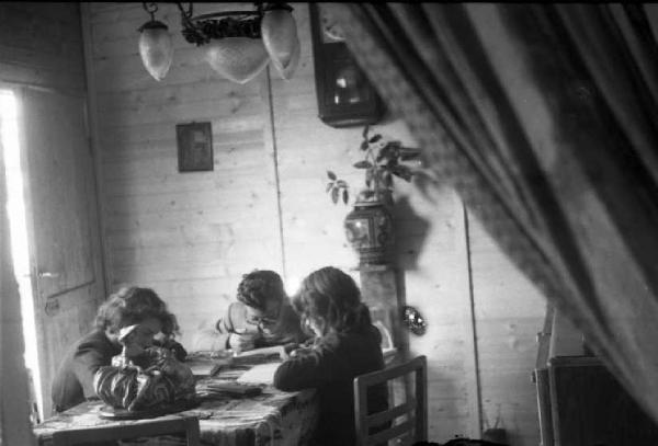 Italia Dopoguerra. Milano - Quartiere Baggio - Alcuni bambini studiano seduti attorno a un tavolo