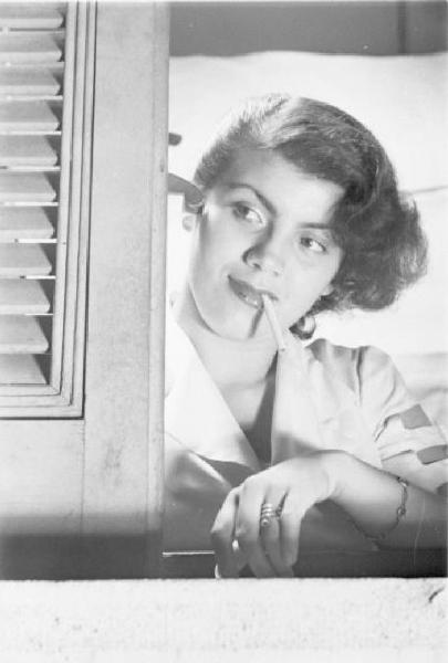Milano - giovane donna alla finestra. Sigaretta in bocca
