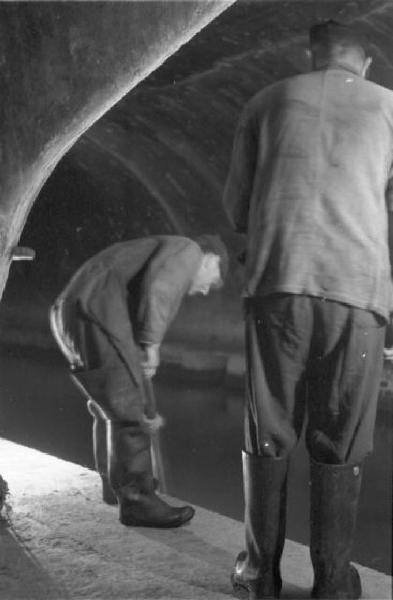 Milano - lavori di manutenzione delle fognature. Operai n galleria alla luce delle torce