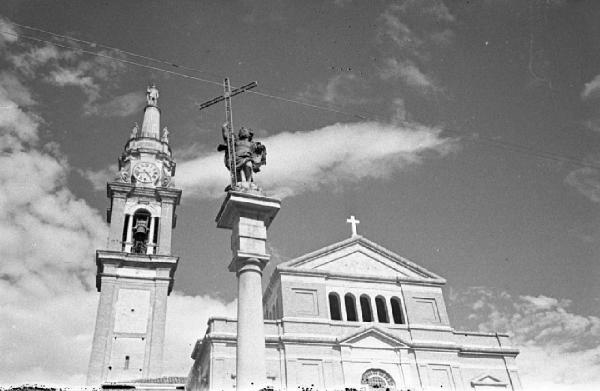 Facciata di una chiesa, campanile e colonna votiva con il Redentore