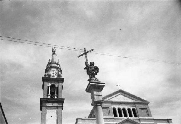 Italia Dopoguerra. Sant'Angelo Lodigiano. Reportage sulla figura di Santa Francesca Cabrini - scorcio dall'esterno della chiesa parrocchiale - in primo piano il campanile e un obelisco con la SS. Madonna