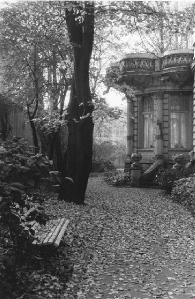 Lodz - Giardini del Museo d'Arte - Vialetto alberato ricoperto di foglie - panchina - sullo sfondo un bovindo della villa