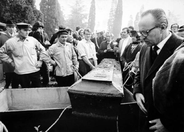 Milano. Cimitero. Esumazione della salma di Giuseppe Pinelli per la perizia. In primo piano la bara - attorno i periti, i becchini, vigili e fotografi - sullo sfondo i cipressi