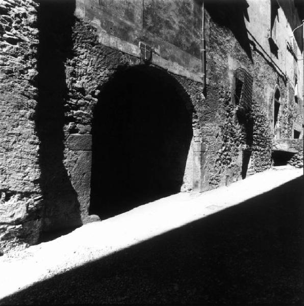 Grosio - Strada con case in pietra - arco d'ingresso ad un cortile sovrastato dallo scudo in pietra simbolo del comune