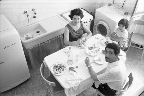 Milano - Abitazione, interno - Cucina - Ritratto di gruppo: famiglia di immigrati durante il pranzo