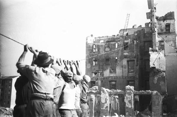 Italia Dopoguerra. Milano - Ricostruzione - Cantiere - Demolizione di un edificio distrutto dai bombardamenti - Operai