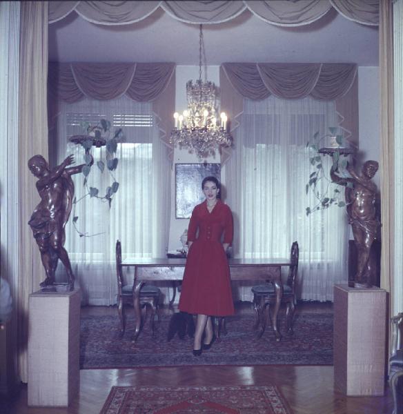 Milano - Abitazione di Maria Callas: interno - Sala da pranzo - Ritratto femminile a figura intera: Maria Callas (cantante lirica) - Cane barboncino sotto il tavolo