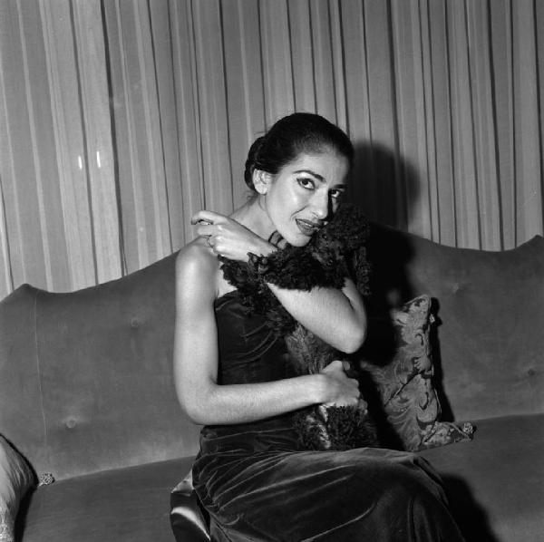 Milano - Abitazione di Maria Callas: interno - Ritratto femminile: Maria Callas (cantante lirica) seduta su un divano - Cane Barboncino