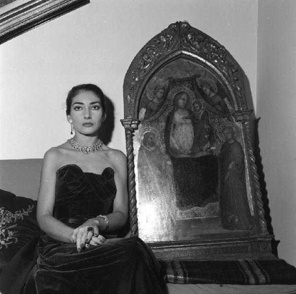 Milano - Abitazione di Maria Callas: interno - Ritratto femminile: Maria Callas (cantante lirica) seduta accanto ad una pala d'altare antica