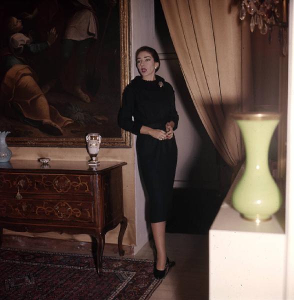 Milano - Abitazione di Maria Callas: interno - Quadro - Tenda - Vasi - Cassettiera antica decorata - Ritratto femminile a figura intera: Maria Callas (cantante lirica)