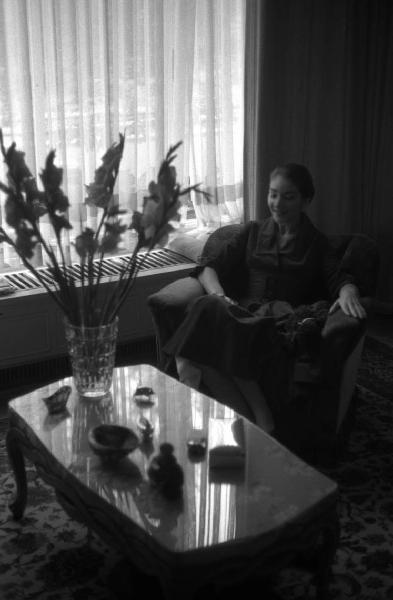 Milano - Abitazione di Maria Callas: interno - Finestra - Tavolino con vaso di fiori - Ritratto femminile: Maria Callas (cantante lirica) seduta su una poltrona - Cane barboncino