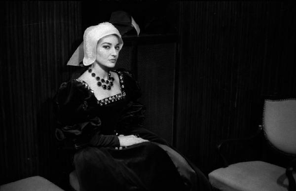 Milano: Teatro alla Scala - Spettacolo Anna Bolena, 1957, regia di Luchino Visconti - Camerino, interno - Ritratto femminile: Maria Callas (cantante lirica) seduta con costume di scena da Anna Bolena