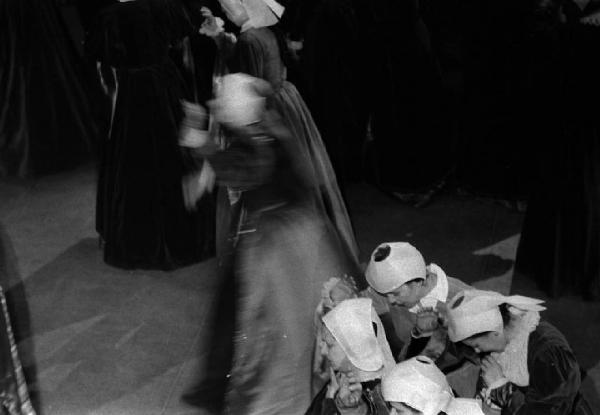 Milano: Teatro alla Scala - Spettacolo Anna Bolena, 1957, regia di Luchino Visconti - Foto di scena - Scenografia - Gruppo di attori sul palco - Donne inginocchiate