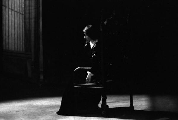 Milano: Teatro alla Scala - Spettacolo Anna Bolena, 1957, regia di Luchino Visconti - Foto di scena - Scenografia - Ritratto femminile: Maria Callas (cantante lirica) seduta su un trono di legno