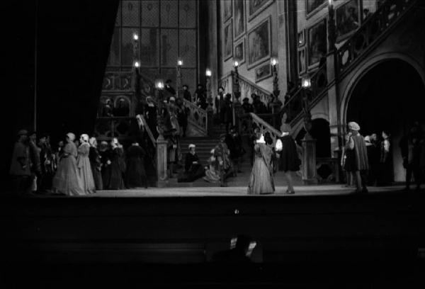 Milano: Teatro alla Scala - Spettacolo Anna Bolena, 1957, regia di Luchino Visconti - Foto di scena - Scenografia - Scalinata - Gruppo di personaggi sul palco - Gianandrea Gavazzeni, direttore d'orchestra di spalle