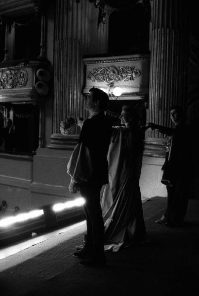 Milano: Teatro alla Scala - Spettacolo Anna Bolena, 1957, regia di Luchino Visconti - Foto di scena - Sipario - Ritratto femminile: Maria Callas (cantante lirica) con attori - Fiori - Palchetti con pubblico