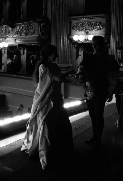 Milano: Teatro alla Scala - Spettacolo Anna Bolena, 1957, regia di Luchino Visconti - Foto di scena - Sipario - Ritratto femminile: Maria Callas (cantante lirica) con attori - Fiori - Palchetti con pubblico