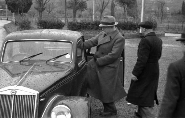 Sopralluogo per il film "Tosca". Tivoli - Villa Adriana - Sito archeologico - Ritratto maschile: Jean Renoir, regista sale in auto - Sopralluogo per il film "Tosca"